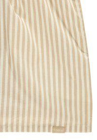 Tessuto rigato in beige chiaro e crema, caratterizzato da strisce verticali con una texture liscia e un'etichetta di marca nell'angolo in basso.