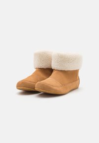 Stivali scamosciati color sabbia con un morbido risvolto in shearling bianco. Il design presenta dettagli in cucitura e una suola in gomma per una buona aderenza.