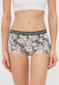 Calções com padrão floral feitos de tecido suave, com um cós elástico verde-escuro que ostenta a marca "BJÖRN BORG".