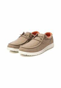 Zapatos de lona beige con suelas blancas, punta redonda, diseño minimalista, forro interior naranja, decorados con cordones ligeros a juego.