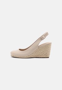 Scarpe slingback con tacco a cuneo beige, con tomaia in pelle liscia e piattaforma intrecciata simile al juta. Punta rotonda e cinturino regolabile con fibbia sul tallone.