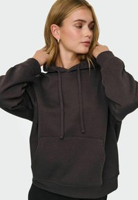 Donkergrijze hoodie met een trekkoordkap, kangoeroezak en geribbelde manchetten. Zachte stof en een losvallend ontwerp.