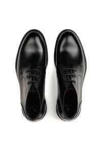 Schwarze Lederschuhe mit glatter Oberfläche, fünf Ösen zum Schnüren, abgerundeter Spitze und dezenten Zierstichen an den Seiten.