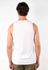 Débardeur en coton blanc avec un col arrondi et de larges emmanchures, présentant une texture lisse et un petit logo sur l'épaule arrière.