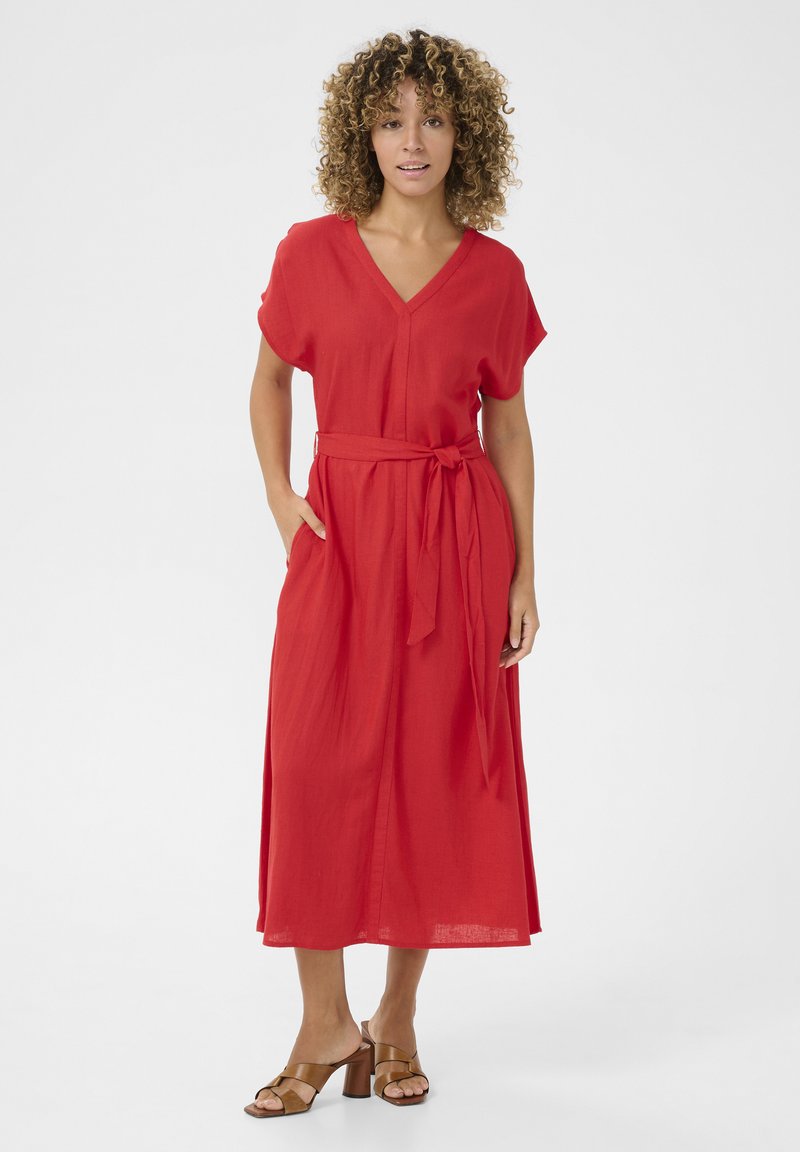 Röd midiklänning med V-ringning, korta ärmar och bälte i tyg. Den har två sidfickor och en avslappnad passform. I kombination med klacksandaler.