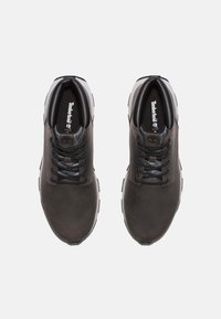 Dark gray leather sneakers with black accents, round toe, textured mesh tongue, and contrasting white sole. Timberland logo on the insole.