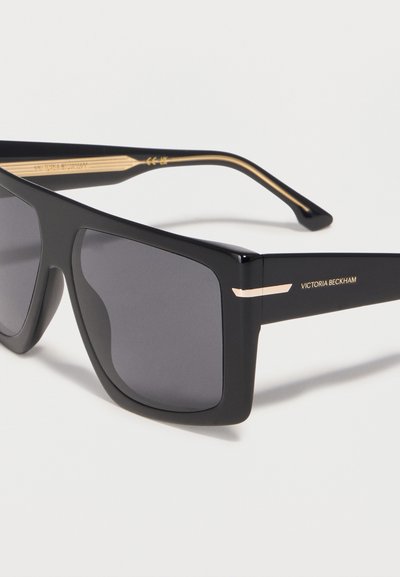 Μαύρα ορθογώνια γυαλιά ηλίου με σκούρους φακούς, χρυσές λεπτομέρειες και την επωνυμία «Victoria Beckham» στο μπράτσο του σκελετού.