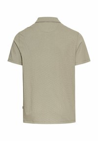 Beige kortærmet polo shirt med en tekstureret mønster, en klassisk krave og en lige kant. Minimalistisk design uden synlige logoer.