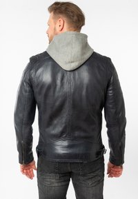 Schwarze Lederjacke mit einer grauen Kapuzenfutter, ausgestattet mit taillierter Passform, Reißverschluss und detaillierter Steppnaht an den Schultern.