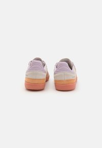 Lage sneakers met een lavendel kleurige suede bovenwerk, textuuraccenten en een oranje rubberen zool. Voorzien van een gevoerde boord en logo op de achterkant.
