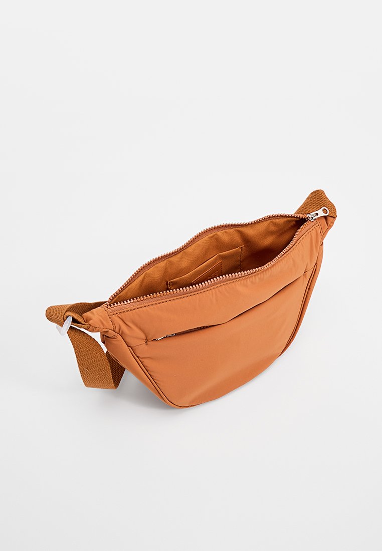 Sac bandoulière en nylon orange avec fermeture zippée, une sangle texturée et un compartiment unique avec une poche intérieure.
