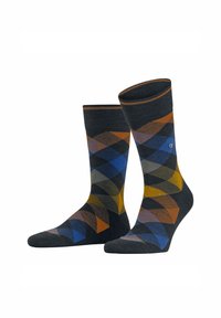Chaussettes à motifs sombres mettant en avant un design en diamants dans des couleurs bleu, orange, jaune et gris, présentées avec un logo visible sur une des chaussettes.