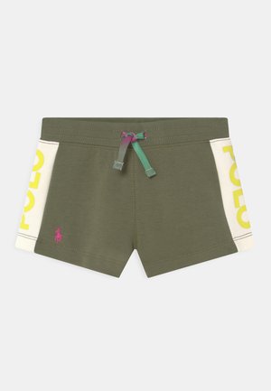 Calções de algodão verdes com um cinto de cordão. Painéis laterais brancos apresentam o texto amarelo "POLO". Logótipo rosa na frente. Textura suave.