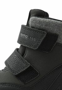 Czarne wodoodporne botki z teksturowaną podeszwą, materiałową cholewką, rzepami oraz szarym filcowym kołnierzem dla dodatkowej izolacji.