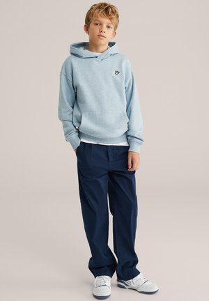 Felpa con cappuccio azzurro chiaro con tasca a marsupio e cappuccio, abbinata a pantaloni blu navy. Scarpe da ginnastica bianche con dettagli blu navy. Design semplice e casual.