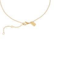 Delicado collar de cadena de oro con cierre de langosta y pequeña etiqueta rectangular sobre un fondo blanco.