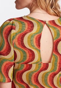 Strickoberteil mit kurzen Ärmeln, das ein mehrfarbiges Wellenmuster in Rot, Grün, Orange und Gold aufweist. Rückenausschnitt, der mit einem Knopf gesichert ist.