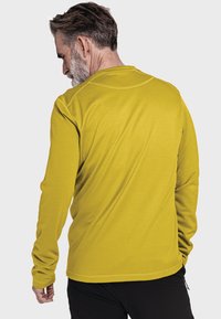 Langärmliges Hemd in Senfgelb, aus glattem Stoff gefertigt, mit Rundhalsausschnitt und flachen Nähten, das ein einfaches, tailliertes Design zeigt.