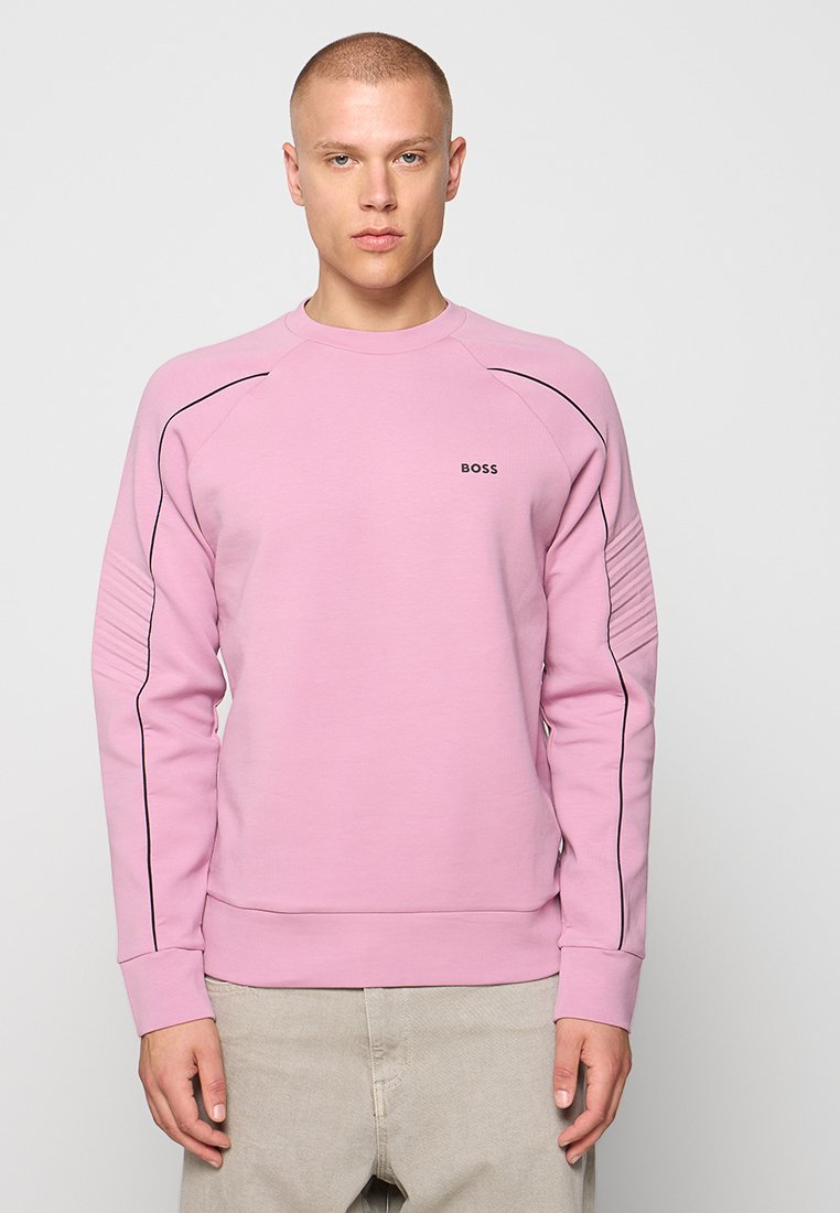 Sweatshirt rose avec un col rond, des lignes noires sur les épaules et des détails côtelés sur les manches. Présente un petit logo sur la poitrine.