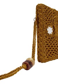 Szydełkowana torba w kolorze musztardowym z geometrycznym wzorem, z okrągłym wycięciem i plecionym paskiem ozdobionym drewnianymi koralikami.