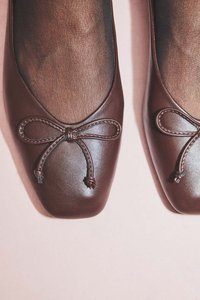 Hnedé kožené ploché topánky so štvorcovou špičkou, s mašľou na prednej strane a hladkým povrchom.