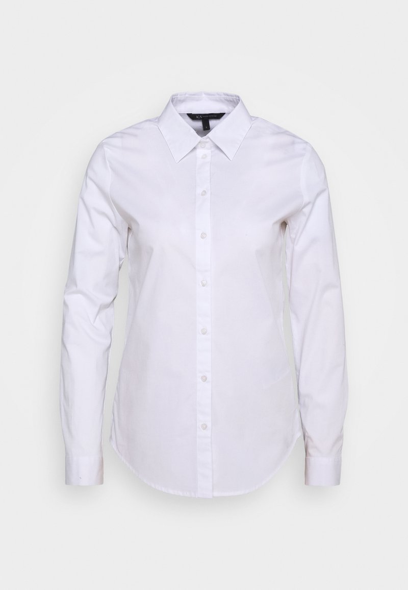 Camicia bianca a maniche lunghe con chiusura a bottoni, colletto e orlo curvo. Realizzata in tessuto morbido con un taglio classico e senza motivi visibili.