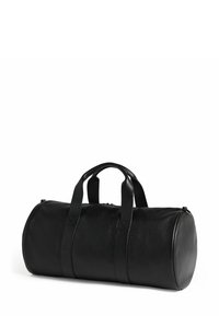 Sac de voyage en cuir noir à forme arrondie, avec deux poignées supérieures et fermeture éclair. Surface texturée avec détails de couture visibles.