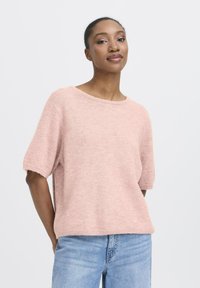 Lichtroze sweater met korte mouwen van zachte, gestructureerde stof met een ronde hals en een relaxte pasvorm, gecombineerd met blauwe denim jeans.