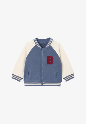 Blue and cream zip-up jacket with a red fabric "B" patch. Features striped ribbed collar and cuffs, side pockets, and a soft texture.
