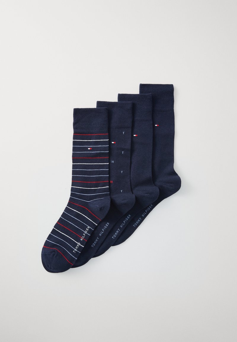 Quatre paires de chaussettes marines : une avec des rayures rouges et blanches, trois unies marines avec de légers accents de logo et une texture lisse.
