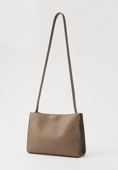Braune Leder-Schultertasche mit glatter Textur, rechteckiger Form und einem langen, schlanken Tragegurt. Auf einer Seite mit einem Reißverschluss gesichert.
