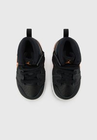 Scarpe sportive nere con accenti arancioni, in pelle perforata e collare imbottito. Presentano lacci e un'etichetta per un facile indossamento.