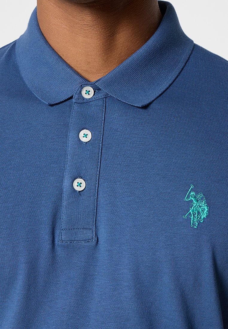 Marineblaues Poloshirt aus Baumwolle, mit klassischem Kragen, drei Knöpfen mit türkisen Akzenten und gesticktem Logo auf der Brust.