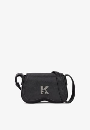 Czarna skórzana torba na ramię o wygiętym kształcie, z metalowym srebrnym akcentem logo i odpinanym paskiem na ramię.