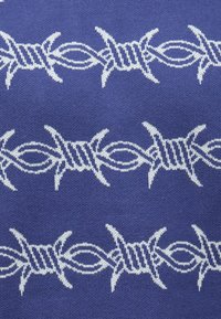 Μπλε ύφασμα με επαναλαμβανόμενο λευκό σχέδιο από συρματοπλέγματα με εξογκώματα, που διαθέτει υφασμένες γραμμές και στροφές, παρουσιάζοντας ένα ξεχωριστό γεωμετρικό σχέδιο.