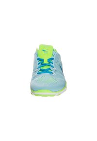 Light blue Nike Free TR Fit 5 sneakers with green accents, mesh upper, textured sole, and blue laces. Prominent branding on tongue.