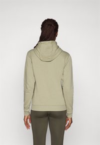 Hoodie i ljus olivgrön, blandning av bomull, långa ärmar, ribbad mudd och nederkant. Har en avslappnad passform och baksidan syns.