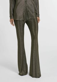 Uitgebreide broek van donker glinsterende stof, met een hoge taille en een glanzende textuur, gecombineerd met een bijpassend shirt met lange mouwen en knopen.