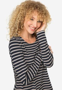 Chemise à rayures bleu marine et beige à manches longues avec un col rond et un tissu doux, présentant une coupe décontractée et un léger drapé.