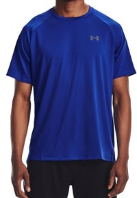 Camiseta atlética de manga corta en azul brillante, hecha de tejido que absorbe la humedad. Presenta un cuello redondo y un logo sutil en el pecho.