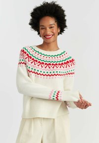 Cream-colored sweater with a patterned yoke in red, green, and pink. Features long sleeves and ribbed cuffs with geometric accents.
