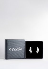 Silverörhängen med bladformade mönster, prydda med flera rundslipade klara stenar, som visas i en svart sammetsklädd låda.