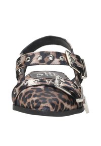 Leopardprint platte schoenen met twee brede banden, zilveren hardware en ronde accenten. Zwarte zool en bovenwerk van zachte stof.
