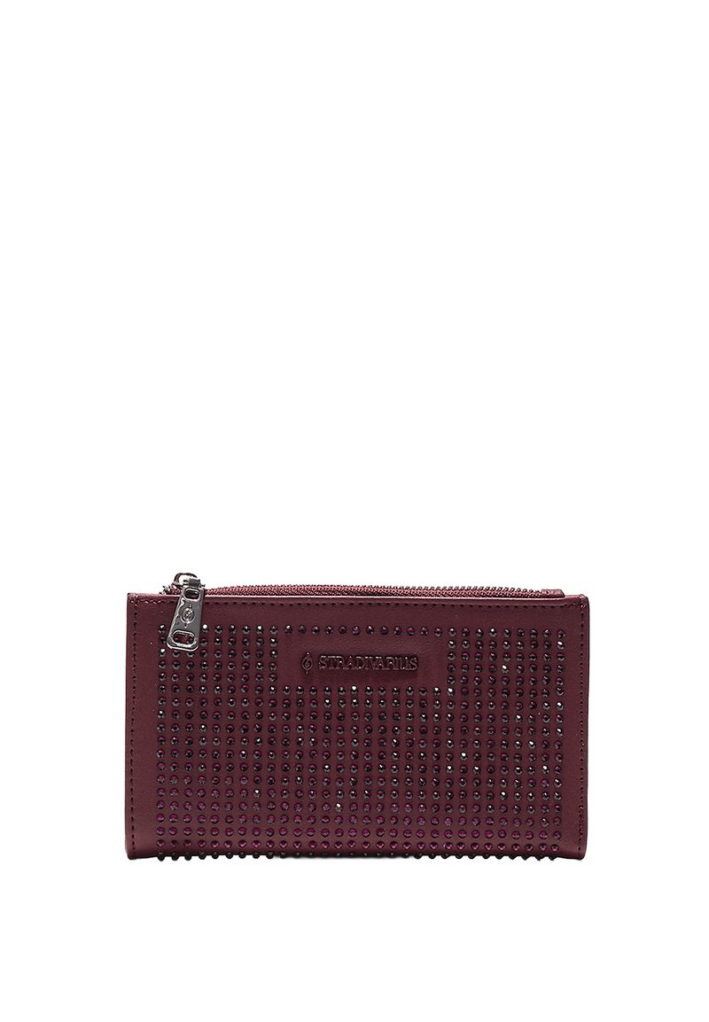 Bordová kožená peňaženka so strieborným zipsom, zdobená radmi malých fialových kryštálov a reliéfnym logom na prednej strane.