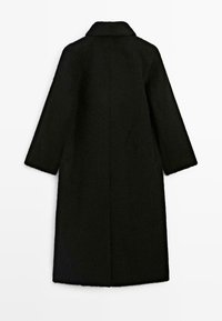 Manteau de laine noir et duveteux avec col cranté et manches larges. Conception mi-longue, sans fermetures ni ornements visibles. Vue arrière simple.