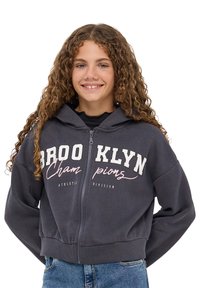 Szary hoodie zapinany na zamek z białym i różowym napisem "BROOKLYN Champions Athletic Division" z przodu, z kapturem na sznurki i ściągaczami przy mankietach.
