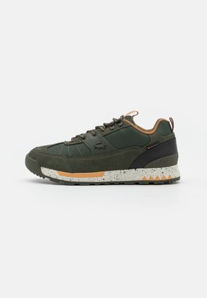 Ciemnozielony sneaker z brązowymi akcentami, nakrapianą białą podeszwą, czarną łatą na pięcie i okrągłymi sznurowadłami widocznymi z boku na białym tle.