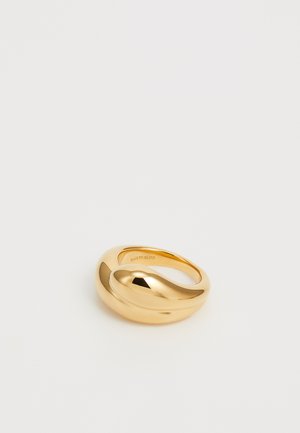 Bague plaquée or avec un design lisse et courbé. Présente une surface brillante, dotée d'une forme asymétrique distinctive et d'un anneau intérieur texturé.