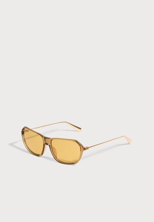 Lunettes de soleil rectangulaires teintées jaune avec des fines branches en métal doré et des montures en plastique marron translucide sur fond blanc.