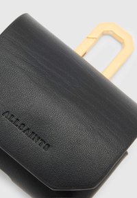 Black textured leather wallet with embossed "ALLSAINTS" logo and a gold-toned geometric metal handle on a light background.
